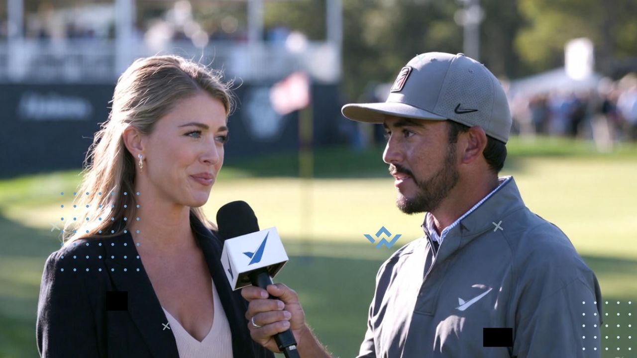 A realistic, professional sports illustration showing Amanda Balionis interviewing Rickie Fowler on a sunny golf course. Amanda holds a microphone with a calm, focused expression, while Rickie, dressed in his signature golf outfit and cap, speaks confidently. The background shows the golf green, flag, and subtle crowd or sponsor banners. The lighting is natural and bright, capturing the energy of a live post-round interview. Use a polished, photo-realistic or semi-realistic style with warm, balanced tones to convey authenticity and importance.
